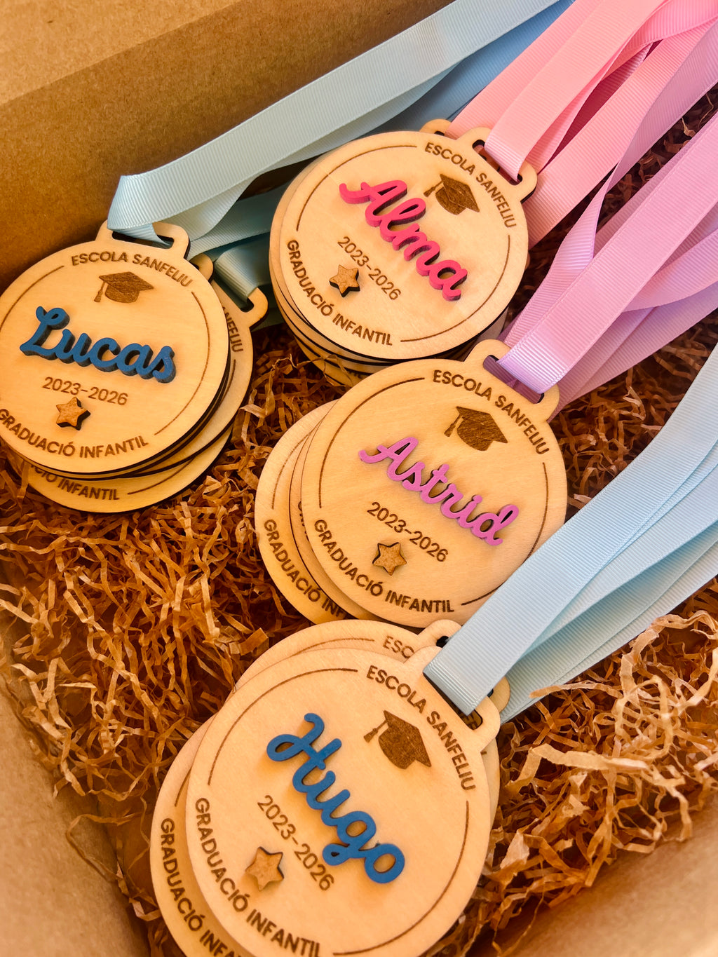 Medallas graduación infantil personalizadas madera con nombres Lucas, Alma, Astrid y Hugo