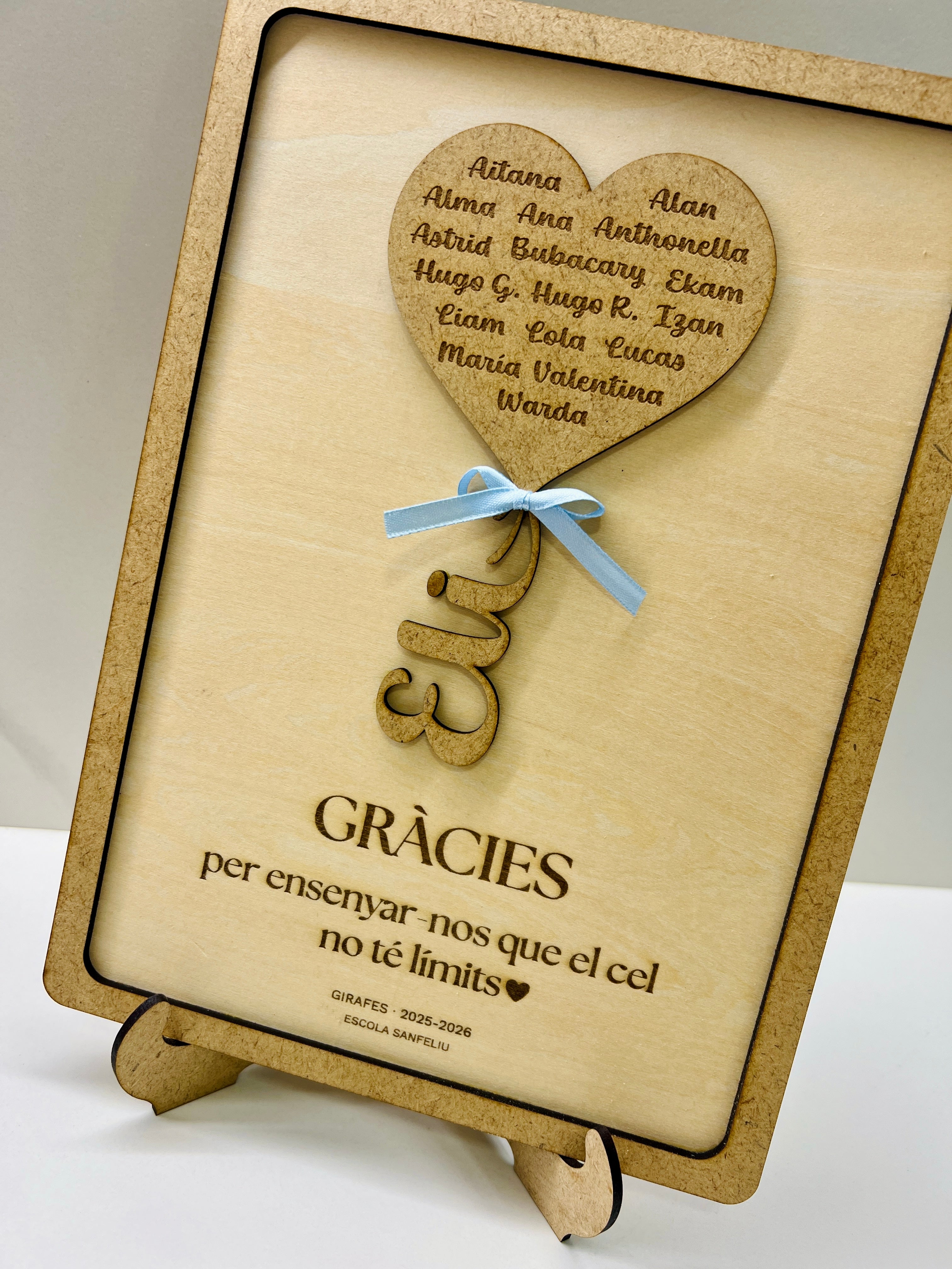 Detalle cuadro personalizado profesora madera con dedicatoria, lacito azul y caballete trasero