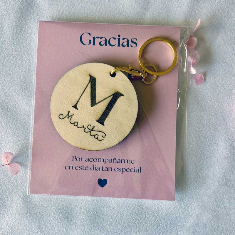 Imagen que resalta la presentación final del producto, incluyendo la tarjeta con mensaje de gratitud y el llavero con la inicial "M" de Marta.